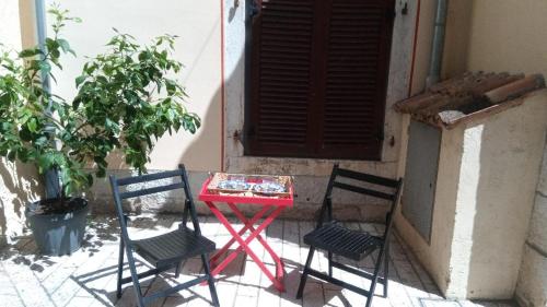duas cadeiras e uma mesa vermelha em frente a um edifício em Old Town Charmer em Porec