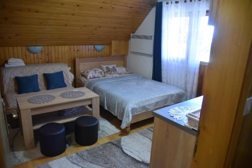 a small bedroom with a bed and a table at Apartment VUK in Žabljak