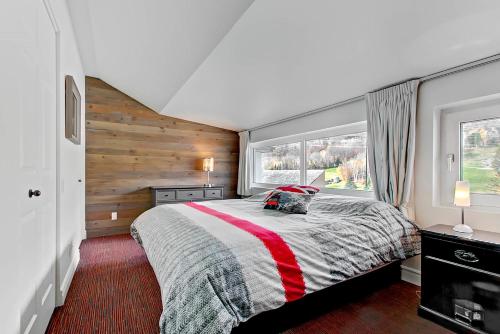 a bedroom with a bed and a window at Hébergement Mont-Ste-Anne Condos in Beaupré