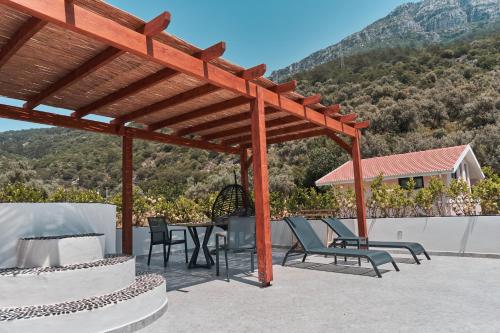 a wooden pergola with a table and chairs on a patio at The Pearl Ölüdeniz in Oludeniz