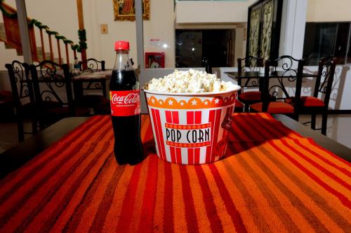 a bottle of soda and a bucket of popcorn on a table at Hotel Kapac Inn-San Blas in Cusco