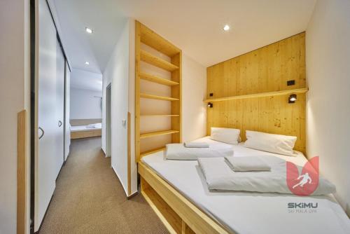 a bedroom with two beds and a wooden headboard at Apartmány Sport Malá Úpa in Horní Malá Úpa