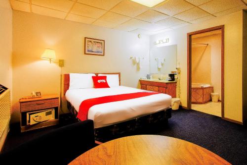 een hotelkamer met een groot bed en een badkamer bij OYO Hotel Chapmanville Inn, WV - Hwy 119 in Chapmanville