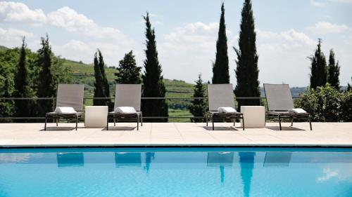 a group of chairs sitting next to a swimming pool at Massimago Wine Relais in Mezzane di Sotto