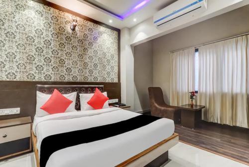 1 dormitorio con 1 cama grande con almohadas rojas en The Ganga Residency, en Bārh