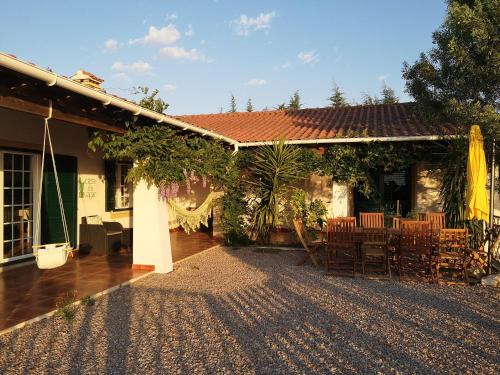 a house with a patio with a table and chairs at Casa do Vagar in Vimieiro
