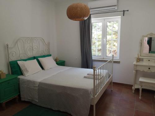 a bedroom with a white bed and a window at Casa do Vagar in Vimieiro