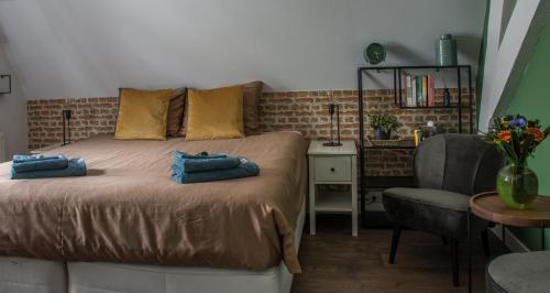a bedroom with a bed with two blue towels on it at Puur & Simpel, Buitengewoon vertoeven in de Brabantse Kempen in Westerhoven