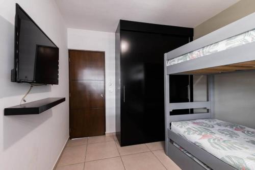 Departamento Joya ideal para tus vacaciones ! في مازاتلان: غرفة نوم مع سرير بطابقين وتلفزيون بشاشة مسطحة