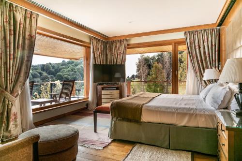 a bedroom with a large window and a large bed at Llao Llao Resort, Golf-Spa in San Carlos de Bariloche