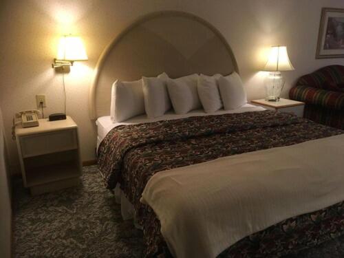 um quarto de hotel com uma cama grande e duas lâmpadas em Value Host Marquette em Marquette