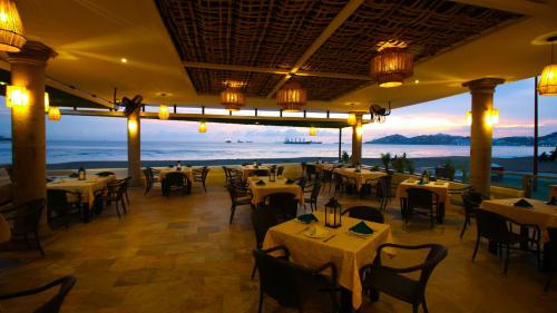 a restaurant with tables and chairs and a view of the ocean at Hotel Marbella in Manzanillo