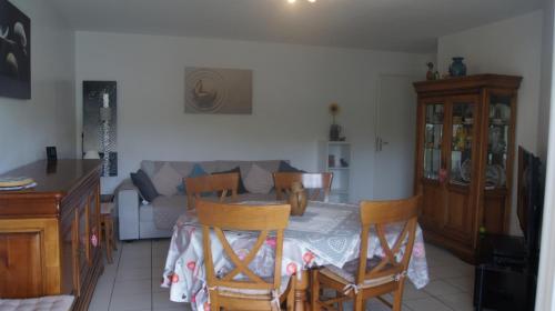 un salon avec une table, des chaises et un canapé dans l'établissement appartement T2 résidence odyssée st Valéry en caux, à Saint-Valery-en-Caux