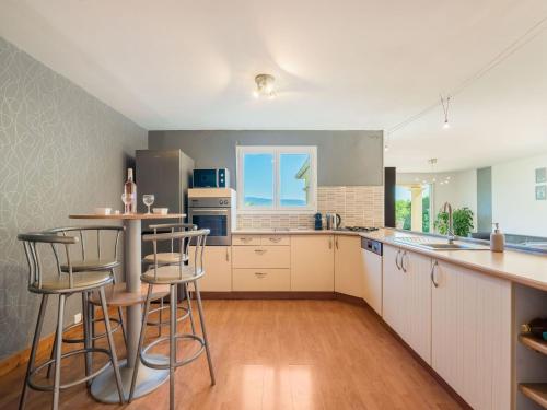 une cuisine avec des armoires blanches et des tabourets de bar dans l'établissement Holiday Home in Les Vans with Private Pool, aux Vans