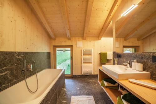 a bathroom with a tub and a sink at Bergchalet Heidi und Peter in San Leonardo in Passiria