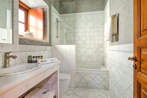 een badkamer met een wastafel, een toilet en een bad bij Mare Monte Luxury Suites in Spetses
