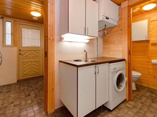 a bathroom with a washing machine and a sink at Holiday Home Amero purnu 4 in Kolinkylä