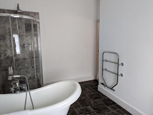 a white bath tub in a bathroom with a shower at Lake View Country House in Grasmere