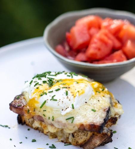 a egg on top of a piece of bread with a bowl of strawberries at Good Medicine Lodge in Whitefish