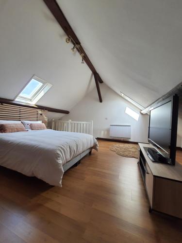1 dormitorio con 1 cama grande y TV de pantalla plana en Duplex cosy à quelques minutes à pied de la mer., en Mers-les-Bains