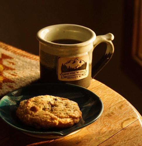 a cookie on a plate next to a cup of coffee at Good Medicine Lodge in Whitefish