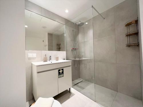 ein weißes Bad mit einer Dusche und einem Waschbecken in der Unterkunft Albufeira Twins 1 With Pool by Homing in Albufeira