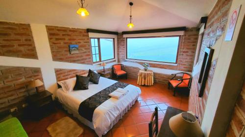 a bedroom with a bed and a brick wall at Balcon al Cotopaxi Hosteria in Sangolquí