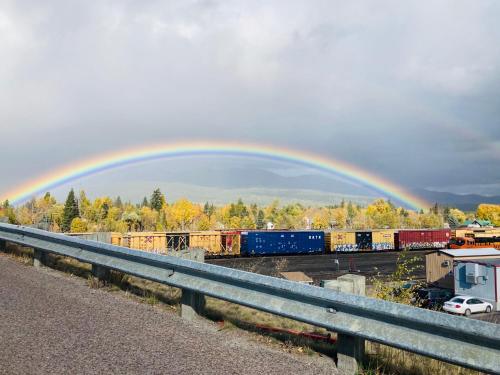 a rainbow over a train yard with a train at Good Medicine Lodge in Whitefish