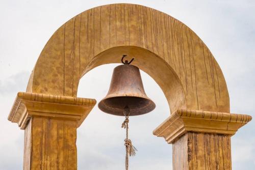 a bell attached to a building with a arch at Villa El Retiro Luxury Property in Alajuela City