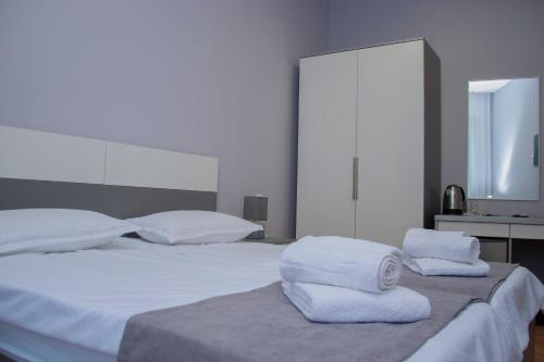 a bedroom with two white towels on a bed at Likani Home in Borjomi