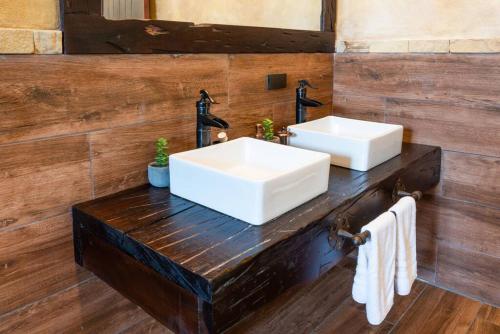 a bathroom with two sinks on a wooden wall at Villa El Retiro Luxury Property in Alajuela City