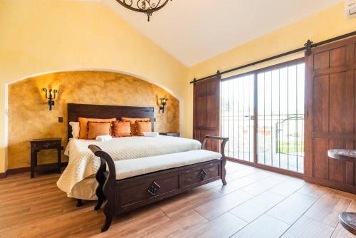 a bedroom with a large bed and a large window at Villa El Retiro Luxury Property in Alajuela City