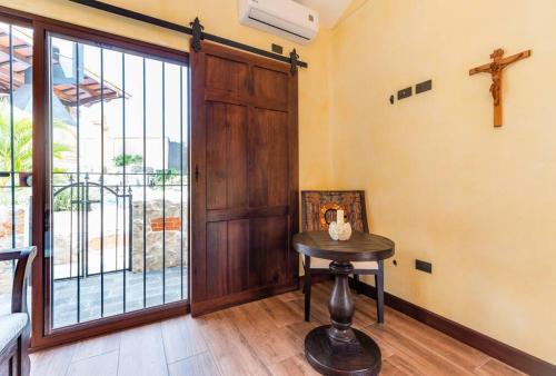 a room with a wooden door and a table and a cross at Villa El Retiro Luxury Property in Alajuela