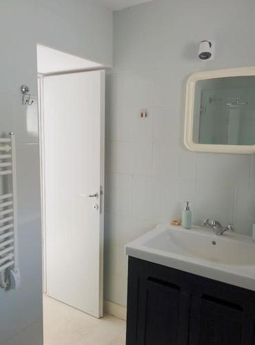 a white bathroom with a sink and a mirror at APARTMANI GOMILA in Jelsa