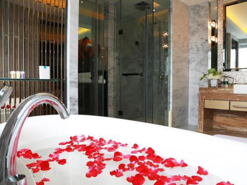 a bathroom with a bath tub with red flowers on it at Ramada Plaza Liuzhou Liudong in Liuzhou