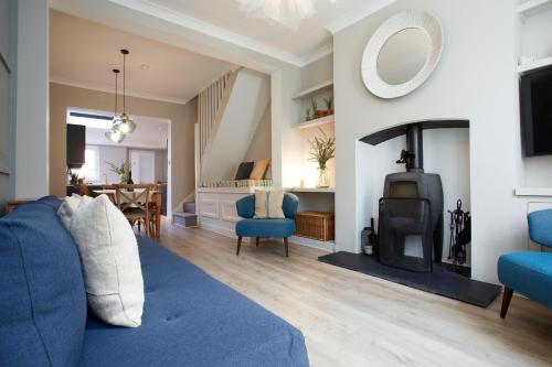 a living room with a blue couch and a fireplace at The Bishy by Chateau Anna, York city centre & free parking in York