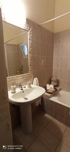a bathroom with a sink and a mirror and a tub at Family Home Myrina Lemnos in Myrina