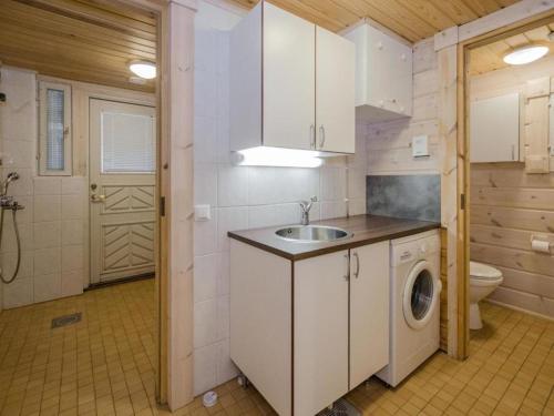 a kitchen with a sink and a washing machine at Holiday Home Amero purnu 5 in Kolinkylä