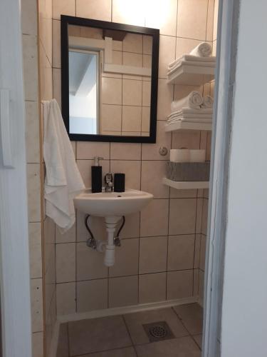 a bathroom with a sink and a mirror and towels at Apartments Ankica in Split