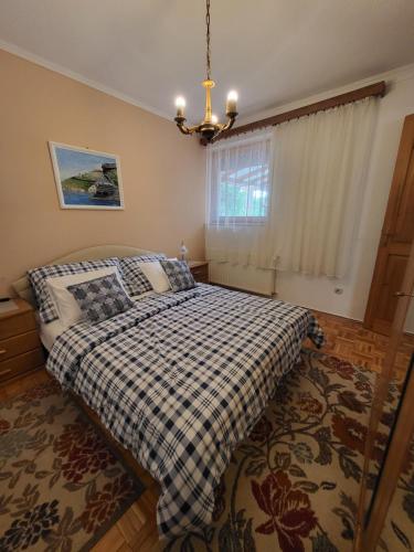 a bedroom with a bed with a checkered blanket at Patkóház in Keszthely