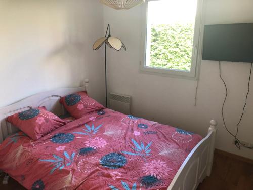 a bedroom with a pink bed with pillows and a window at Appartement Idéal circuit 3km in Le Mans
