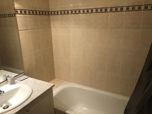 a bathroom with a white tub and a sink at Appartement Idéal circuit 3km in Le Mans
