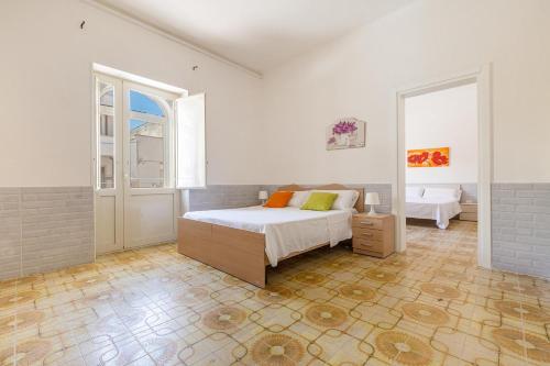 um quarto branco com uma cama e uma janela em Residence Bellavista by BarbarHouse em Torre Lapillo