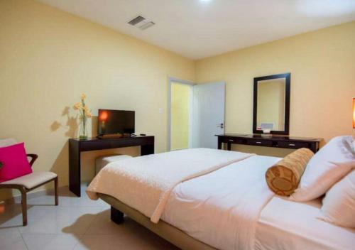 a bedroom with a bed and a desk and a television at Apartamento en Oranjestad Aruba Zona de Cruceros in Oranjestad