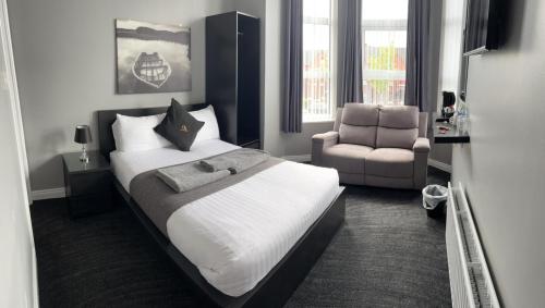 um quarto com uma cama grande e uma cadeira em Citi North em Belfast