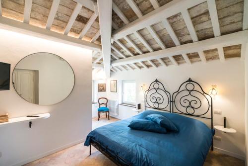 a bedroom with a blue bed and a mirror at Villa9centob&b in Castel di Lama