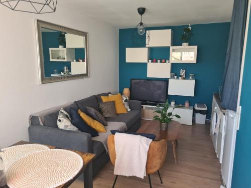 - un salon avec un canapé et une télévision dans l'établissement Appartement T2 27m² meublé vue mer, 50m de la plage, à Narbonne