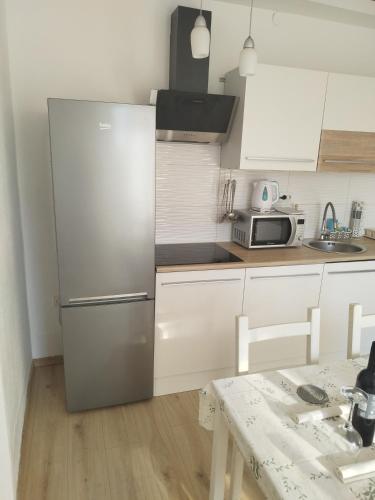a kitchen with a stainless steel refrigerator and a table at CHERISH in Novalja