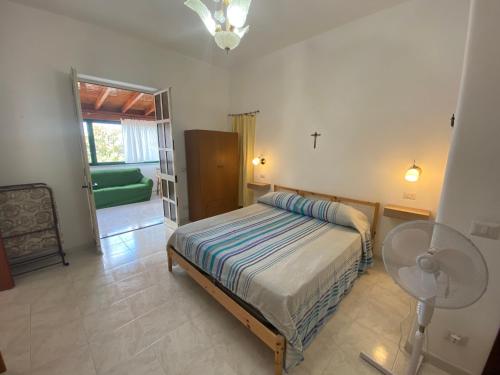 a bedroom with a bed and a table and a fan at Fiordaliso - Holiday Housing in Lipari
