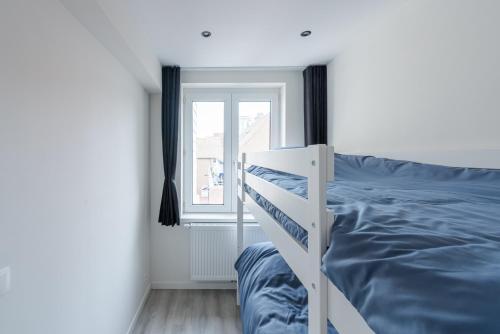 a white bed in a room with a window at Sunny Sea Terkade in Ostend